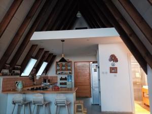 法馬古斯塔的住宿－Country House By The Sea 1，一间带木梁的厨房和一个带凳子的厨房岛