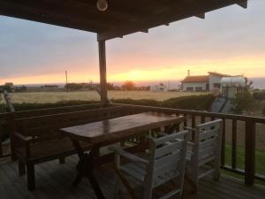 法馬古斯塔的住宿－Country House By The Sea 1，甲板上的木桌和椅子,享有日落美景