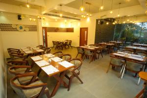 a dining room with wooden tables and chairs at Royalton Residency in Mundakāyam