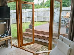 a screened in porch with a sliding glass door at Black Thorn Cottage in Falmouth