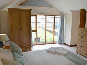 a bedroom with a bed and a large window at Black Thorn Cottage in Falmouth