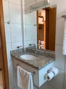 a bathroom with a sink and a mirror and towels at No GOLDEN DOLPHIN EXPRESS VOCÊ IRÁ TER MOMENTOS ESPETACULARES! in Caldas Novas