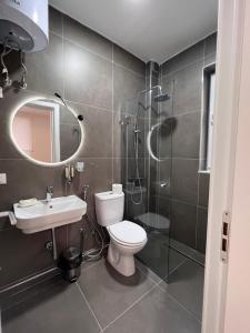 y baño con aseo, ducha y lavamanos. en Grand Park & Bllok Area Rooms en Tirana