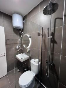 La salle de bains est pourvue de toilettes, d'un lavabo et d'une douche. dans l'établissement Grand Park & Bllok Area Rooms, à Tirana