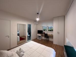 Schlafzimmer mit einem großen weißen Bett und einem Schreibtisch in der Unterkunft Grand Park & Bllok Area Rooms in Tirana