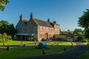 a large brick house with a playground in front of it at Rollestone Coach House in Shrewton