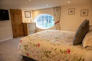 Un dormitorio con una cama grande y una ventana en Rollestone Coach House en Shrewton