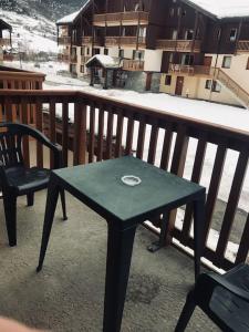 a green table and a chair on a balcony at Pour 4 pers résidence 4* au pied des pistes in Lanslebourg-Mont-Cenis