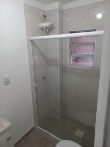 y baño con ducha, aseo y lavamanos. en Apartamento living, en São Vicente