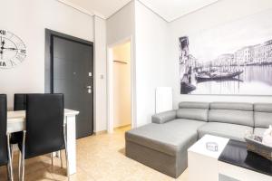 un salon avec un canapé et une table dans l'établissement Renovated penthouse in the center of Larissa, à Larissa