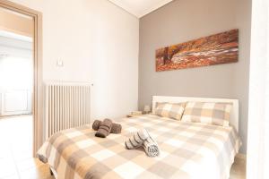 une chambre avec un lit avec deux pantoufles dessus dans l'établissement Renovated penthouse in the center of Larissa, à Larissa
