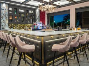 un bar con una fila de taburetes en un restaurante en voco - The Cadence, an IHG Hotel en Niagara Falls