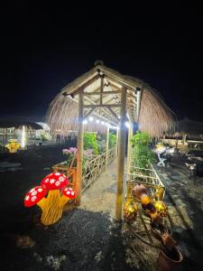a pavilion with a straw umbrella on the beach at night at مزرعة دريم للتأجير 