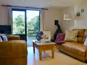 a living room with a couch and a coffee table at Clematis Cottage in Holsworthy