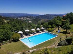 uma piscina num campo com cadeiras em Retiro de Basto em Celorico de Basto