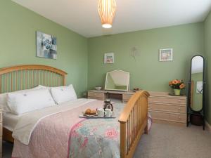 a bedroom with a bed with a table and a mirror at Highbury Annexe in Frampton on Severn