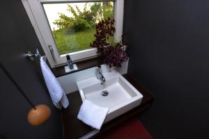 ein Bad mit einem weißen Waschbecken und einem Fenster in der Unterkunft Weinberg 12 in Fehring