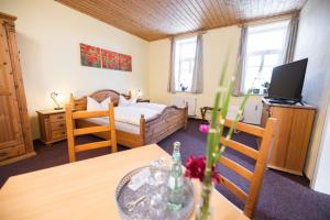 a small room with a bed and a table with a dining room at Pension Friedrichshof in Bad Klosterlausnitz