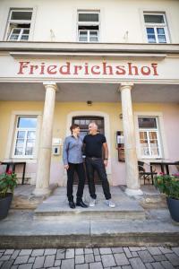 duas pessoas em frente a um edifício em Pension Friedrichshof em Bad Klosterlausnitz