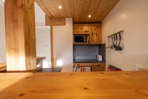 a kitchen with wooden cabinets and a wooden table at Amanuq lovely apartment in Chamonix