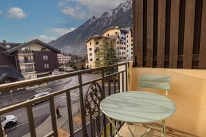 einen Balkon mit einem Tisch und Stadtblick in der Unterkunft Amanuq lovely apartment in Chamonix-Mont-Blanc