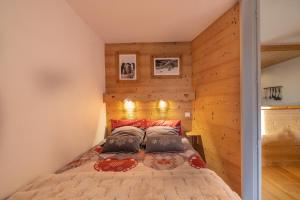 a bedroom with a bed with wooden walls at Amanuq lovely apartment in Chamonix
