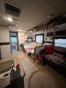 een rv woonkamer met een bank en een bed bij Brisas de Isabela Cozy Glamper 1A in Isabela