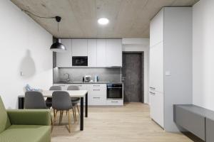 a kitchen and dining room with a table and chairs at Aparthotel Na Klenici in Mladá Boleslav