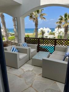een patio met stoelen en uitzicht op de oceaan bij Sky Villa in Paphos City