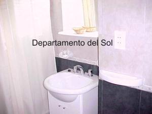 een badkamer met een witte wastafel en een toilet bij Departamentos del Sol in Necochea