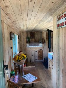a kitchen with a table with a bowl of fruit on it at The Big Green Shepherds Hut in Charlwood +12 photos