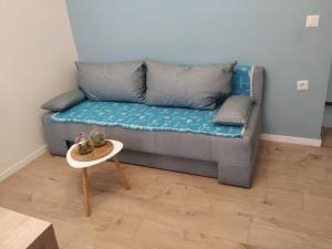 un sofá con almohadas y una mesa en la sala de estar. en Blue & Rose - Quiet & Best Location in town - Self check-in, en Sarajevo