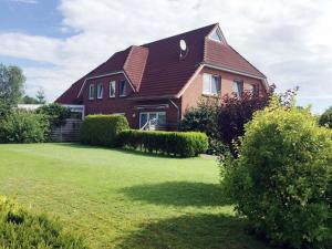 a house with a large lawn in front of it at FeWo Marianne in Neukamperfehn