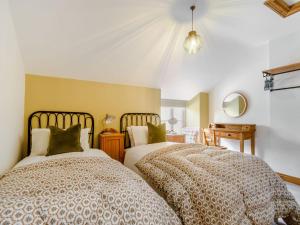 a bedroom with two beds and a mirror at 1 Chapel Terrace in Ebberston