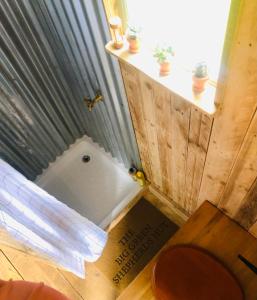 a bathroom with a bath tub in the floor at The Big Green Shepherds Hut in Charlwood