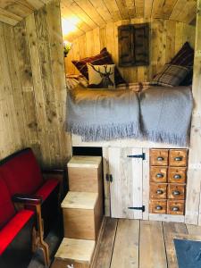 a bedroom with a bed in a wooden cabin at The Big Green Shepherds Hut in Charlwood