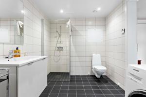 ein weißes Bad mit einem WC und einer Dusche in der Unterkunft Majorstuen Apartments by Key Butler in Oslo