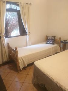 Duas camas num quarto com uma janela em Chacara 70 km de SP - A tranquilidade do campo com conforto da cidade em Itupeva