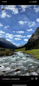 a picture of a river with mountains in the background at Ala-Kul guesthouse in Altyn-Arashan in Karakol