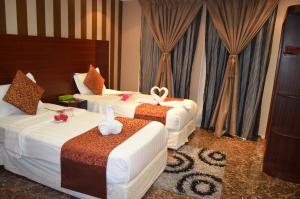 a hotel room with three beds with bows on them at قصر البرونز in Al Khobar