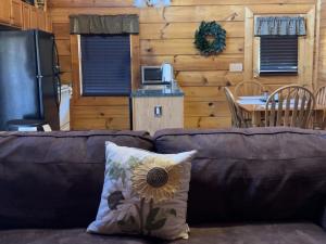 a couch with a sunflower pillow in a living room at Story Brook: Beautiful true log cabin! Close to Dollywood, State Park, and more! in Sevierville
