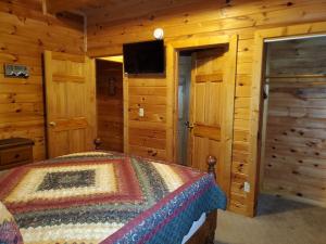 a bedroom with a bed in a wooden cabin at Story Brook: Beautiful true log cabin! Close to Dollywood, State Park, and more! in Sevierville