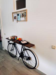 un vélo garé à côté d'un mur avec une table sur le mur dans l'établissement Casa isabel, à Setenil de las Bodegas