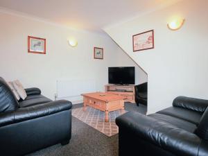 ein Wohnzimmer mit 2 Sofas und einem TV in der Unterkunft Tom Putt in Ledbury