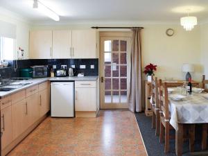 a kitchen with a table and a dining room at Tom Putt in Ledbury