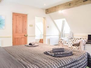 a bedroom with a large bed with towels on it at Holly Cottage in Lilleshall