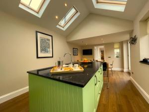 una cocina con una isla verde en una habitación con tragaluces en Wordsworth House, en Keswick