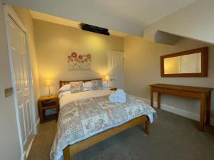1 dormitorio con 1 cama, 2 mesas y espejo en Wordsworth House, en Keswick