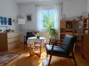 un soggiorno con tavolo, sedia e finestra di Apartment HAUS MERLIN am Böckelsberg a Weimar