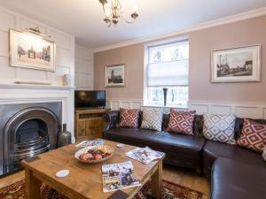 a living room with a leather couch and a table at Beverley Minster House in Beverley